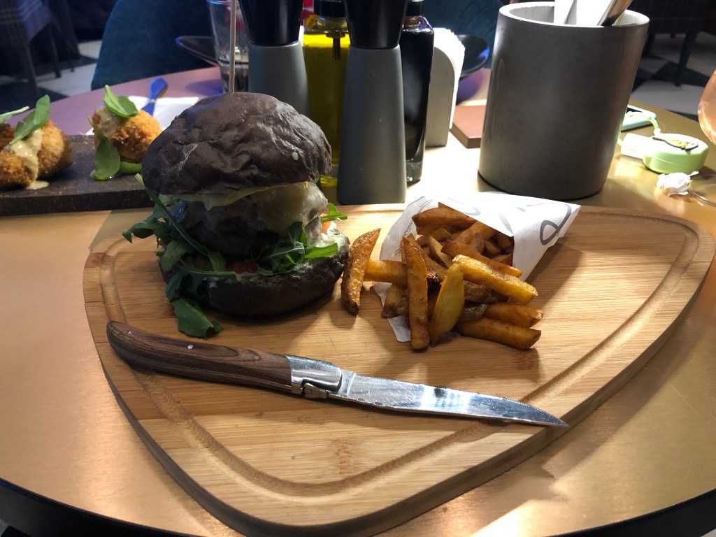 A burger with black buns.