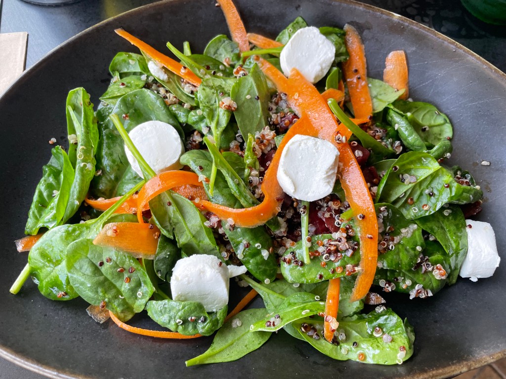 Spinach salad with quinoa and goat cheese.