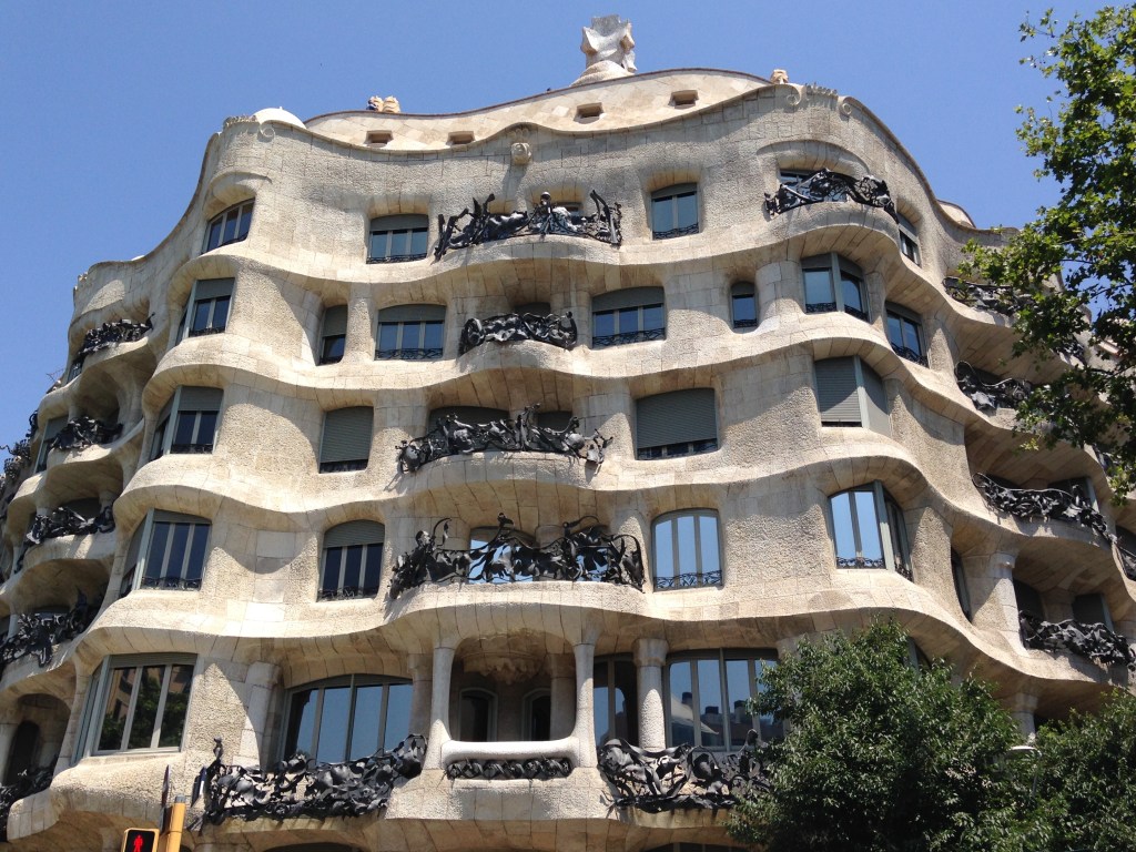 A picture of the curvy façade of Casa Mila. The wrought-iron balcony banisters are visible.