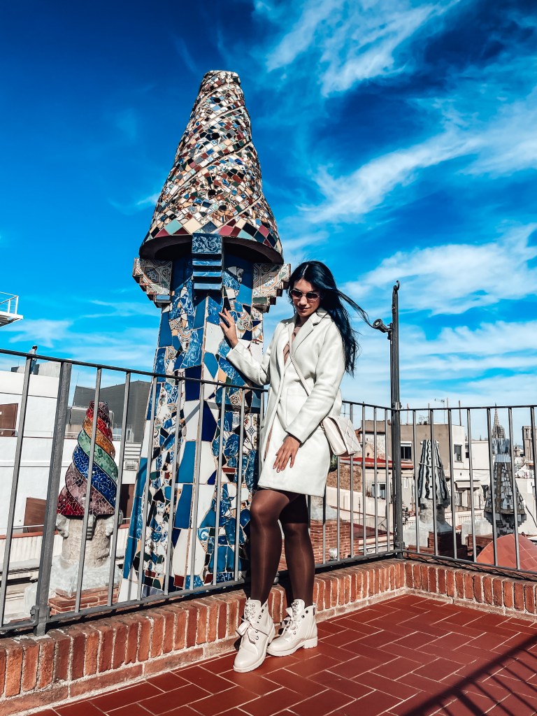 The author with one of the mosaic chimneys on top of Palau Guell.