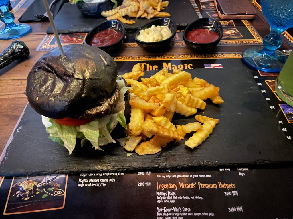 A black burger with fries at The Magic
